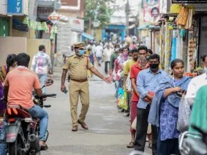 A policeman (C) patrols as people queue to receive free rice distributed at a government civil supply store during a government-imposed nationwide lockdown as a preventive measure against the COVID-19 coronavirus, in Hyderabad on April 1, 2020. NOAH SEELAM / AFP