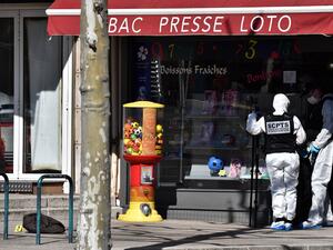 A French Police Judiciaire officer wearing a protective suits holds a camera on a tripod in the centre of Romans-sur-Isere, on April 4, 2020, after a man attacked several people with a knife, killing two and injuring seven before being arrested, according to sources close to the investigation. JEFF PACHOUD / AFP