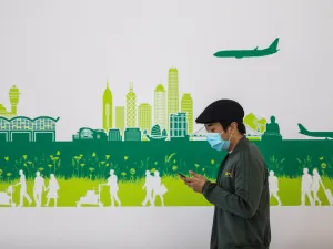 In this picture taken on April 4, 2020, a man wearing a face mask, amid concerns of the COVID-19 coronavirus, walks through the arrivals hall at Hong Kong International Airport. DALE DE LA REY / AFP