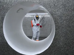 Workers wearing protective suits spray disinfectant at the Centrum subway station in Warsaw on April 6, 2020. JANEK SKARZYNSKI / AFP