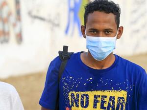 A Sudanese volunteer, wearing a protective face mask, looks at the camera in the capital Khartoum on April 8, 2020, as a group of youth clear debris from a street during a COVID-19 awareness-raising campaign. Sudan. (AFP/ File PHoto)