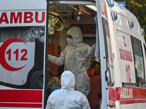 First aid workers wearing protectional equipment looks after a woman suspected of being infected with COVID-19, as she is evacuated by ambulance on April 12, 2020 in Istanbul, during a two-day curfew to prevent the spread of the epidemic COVID-19 caused by the novel coronavirus. Ozan KOSE / AFP