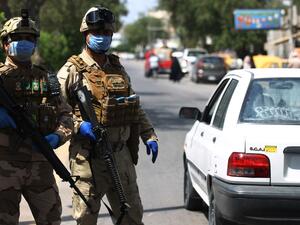 Iraqi soldiers stand at a checkpoint in the Adhamiya district of Baghdad on April 13, 2020 as Iraq imposed a curfew during the coronavirus COVID-19 pandemic. AHMAD AL-RUBAYE / AFP