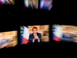 French President Emmanuel Macron is seen on multiple monitors in Paris, as he speaks from the Elysee Palace during a televised address to the nation on April 13, 2020, on the 28th day of a lockdown in France aimed at curbing the spread of the COVID-19 pandemic, caused by the novel coronavirus. The French president in a prime-time televised address announced the coronavirus lockdown in place since March 17, 2020, will go on until May 11, while also outlining how the country will take steps to recover.  Marti