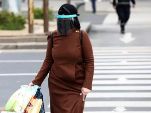 A woman wearing a face-shield and plastic gloves for protective measures crosses the streets as the spread of the COVID-19, the novel coronavirus continues in Ankara, on April 16, 2020. Adem ALTAN / AFP