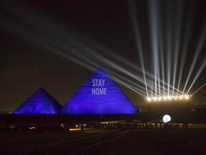 A picture taken on April 18, 2020 show the Great pyramids lighten-up with blue light and reading with a laser projection the message "Stay Home" on the Giza plateau outside the Egyptian capital of Cairo, on the world heritage day, as the country fights against the spread of the COVID-19, (the novel coronavirus). Khaled DESOUKI / AFP