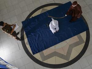 A woman (C) is whipped by the religious police in a public building in Banda Aceh on April 21, 2020, as punishment after he was caught in close proximity with a man who is not her husband in a hotel. AFP
