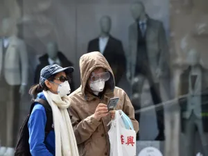 People wear face masks as they walk on a street on April 21, 2020 in front of closed stores in Munich, southern Germany, amid the new coronavirus COVID-19 pandemic. Christof STACHE / AFP