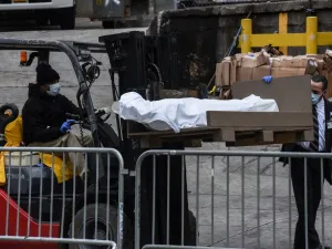 A worker uses a forklift to move a body outside of the Brooklyn Hospital on March 31, 2020 in New York, United States. Due to a surge in deaths caused by the Coronavirus, hospitals are using refrigerator trucks as make shift morgues. Stephanie Keith/Getty Images/AFP STEPHANIE KEITH / GETTY IMAGES NORTH AMERICA / Getty Images via AFP
