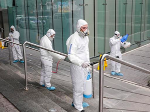Employees of a private company spray sanitising liquid around a bank to limit the spread of the coronavirus in the Lebanese capital Beirut [Anwar Amro/AFP]