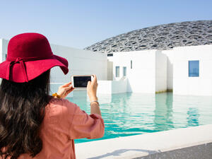 Female tourist taking picture of Louvre Abu Dhabi building. (Shutterstock/ File Photo)