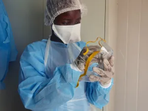Medical staff of International Medical Corps (IMC) put on Personal Protective Equipment (PPE) at the isolation ward of Ministry of Health Infectious Disease Unit in Juba, South Sudan, on April 24, 2020. The national facility hosts South Sudan’s fifth case of the COVID-19 Coronavirus, who was admitted yesterday. Alex McBride / AFP