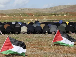 In this file photo taken on January 31, 2020 Palestinian protesters perform the Friday prayer behind national flags during a protest against a US brokered Middle East peace plan, outside the West Bank village of Tamun near the Jordan Valley, on January 31, 2020. Arab foreign ministers are to hold talks on April 30, 2020 on Israel's US-backed plans to annex key parts of the occupied West Bank. Concern has mounted since Israel's right-wing Prime Minister Benjamin Netanyahu -- an outspoken advocate of annexing