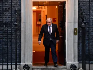 Britain's Prime Minister Boris Johnson walks of 10 Downing Street in central London on April 30, 2020, to participate in a national "clap for carers" to show thanks for the work of Britain's NHS (National Health Service) workers and other frontline medical staff around the country as they battle with the novel coronavirus pandemic, in the doorway of ˜Britain is "past the peak" of its coronavirus outbreak, Prime Minister Boris Johnson said Thursday, despite recording another 674 deaths in the last 24 hours, 