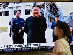 A woman walks past a television news screen showing a picture of North Korean leader Kim Jong Un attending a ceremony to mark the completion of Sunchon phosphatic fertiliser factory, at a railway station in Seoul on May 2, 2020. North Korea's Kim Jong Un has made his first public appearance in nearly three weeks, state media reported on May 2, following intense speculation that the leader of the nuclear-armed nation was seriously ill or possibly dead. Jung Yeon-je / AFP