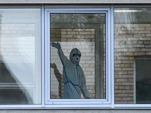 A health worker wearing protective equipment waves behind a window inside a hospital where patients infected with the COVID-19 are being treated in Khimki, outside Moscow on May 3, 2020 amid the COVID-19 outbreak, caused by the novel coronavirus. Russia on May 3, 2020 reported its largest increase in coronavirus cases with the new infections rising by more 10,000 in a single day. Kirill KUDRYAVTSEV / AFP