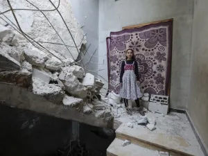 A Syrian girl whose family decided to return home for fear of the COVID-19 pandemic in packed camps for the internally displaced, poses for a picture amid the rubble in her damaged house in al-Nayrab, a village ravaged by pro-government forces bombardment near the M4 strategic highway, in Syria's northwestern Idlib province, on May 3, 2020. Bakr ALKASEM / AFP