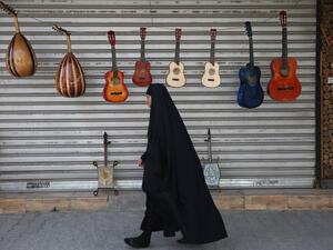 An Iraqi woman walks past musical instruments for sale in central Baghdad on May 5, 2020 during of the Muslim holy month of Ramadan after authorities eased up the lockdown measures that they had imposed in a bid to slow the spread of the novel coronavirus Covid-19. AHMAD AL-RUBAYE / AFP