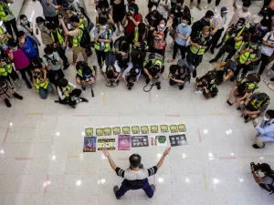 Journalists watch a pro-democracy demonstrator protests calling for the city's independence in Hong Kong on May 10, 2020. ISAAC LAWRENCE / AFP