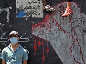 An Iraqi protester, wearing a protective mask, is pictured on the Al-Jumhuriyah bridge in the capital Baghdad on May 11, 2020, during an anti-government demonstration. Modest anti-government rallies resumed in some Iraqi cities Sunday, clashing with security forces and ending months of relative calm just days after Prime Minister Mustafa Kadhemi's government came to power. The protests first erupted in Baghdad and Shiite-majority southern cities in October, demanding an end to corruption and unemployment an