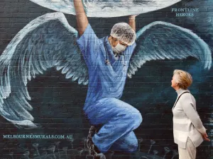A woman looks at a mural of a health worker with wings holding a globe on International Nurses Day in Melbourne on May 12, 2020. As frontline hospital staff are constantly facing the risks from the COVID-19 coronavirus outbreak, the world is marking International Nurses Day, celebrated around the world every May 12, the anniversary of Florence Nightingale's birth. William WEST / AFP