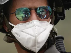 The images of two Israeli soldiers are projected on the sunglasses of a third one wearing a mask against the coronavirus Covid-19 during a protest by Palestinians against Israeli settlements on May 15, 2020 in al-Sawiya village, south of Nablus, in the occupied West Bank. JAAFAR ASHTIYEH / AFP