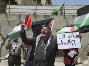 Mask-clad Palestinians demonstrate along the controversial separation barrier at the western entrance of the northern West Bank city of Tulkarem on May 16, 2020, marking the 72nd anniversary of Nakba (catastrophe). (AFP/File)