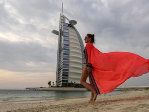 A woman bather walks along the beach shoreline near the Burj al-Arab hotel in Dubai on May 20, 2020, as COVID-19 coronavirus pandemic lockdown measures are eased in the Gulf emirate. Karim SAHIB / AFP