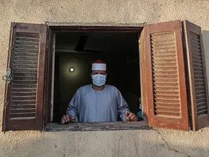 The Imam of a local mosque in the village of Shamma in Egypt's northern Nile delta province of Menoufia stands clad in mask due to the COVID-19 coronavirus pandemic by a window near the mosque early on May 24, 2020, before the prayers of Eid al-Fitr, the Muslim holiday which starts at the conclusion of the holy fasting month of Ramadan. (AFP/File Photo)