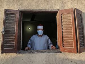 The Imam of a local mosque in the village of Shamma in Egypt's northern Nile delta province of Menoufia stands clad in mask due to the COVID-19 coronavirus pandemic by a window near the mosque early on May 24, 2020, before the prayers of Eid al-Fitr, the Muslim holiday which starts at the conclusion of the holy fasting month of Ramadan. (AFP/File Photo)