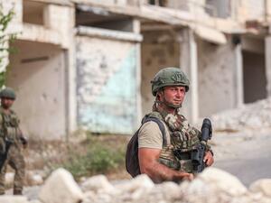 Turkish soldiers patrol along a road past destroyed buildings atop the Arbaeen hill overlooking Ariha in the southern countryside of Syria's Idlib province on May 26, 2020. OMAR HAJ KADOUR / AFP