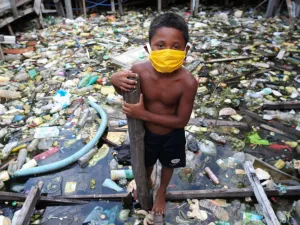 A boy from the Educandos riverside community wears a face mask during the COVID-19 coronavirus pandemic in Manaus, the Amazon on May 26, 2020. The Nossa Senhora Perpetuo Socorro church has been handing out masks to impoverished members of its community to assist in the fight against the spread of the novel coronavirus. MICHAEL DANTAS / AFP