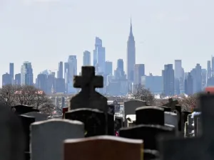 In this file photo Gravestones from Linden Hill Methodist Cemetery are seen with the Manhattan skyline in the background in Brooklyn, New York. The United States has now recorded more than 100,000 coronavirus-related deaths, Johns Hopkins University reported Wednesday -- a somber milestone and by far the highest total in the world. The country reported its first death about three months ago. Since then, nearly 1.7 million infections have been tallied nationwide, according to the Baltimore-based school. The 