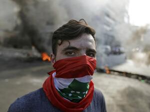 A Lebanese protester stands in front of burning tyres and debris in the area of Jal el-Dib, on the northern outskirts of the Lebanese capital Beirut, on November 13, 2019. A man was shot dead south of Beirut after the army opened fire to disperse protesters blocking roads, Lebanese state media said, nearly a month into an unprecedented anti-graft street movement. JOSEPH EID / AFP