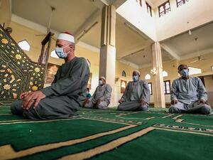 An Imam leads a handful of Muslim worshippers, all clad in masks due to the COVID-19 coronavirus pandemic, during the prayers of Eid al-Fitr, the Muslim holiday which starts at the conclusion of the holy fasting month of Ramadan, inside a mosque in the village of Shamma in Egypt's northern Nile delta province of Menoufia early on May 24, 2020. (AFP/File)