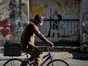 A man wears a face mask as he rides a bicycle in Havana, on May 25, 2020. Cuba reported 1947 confirmed cases of COVID-19 and 82 deceased due to the virus. YAMIL LAGE / AFP