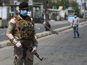 A member of the Iraqi security forces stands guard at a checkpoint, enforcing a curfew due to the COVID-19 coronavirus pandemic, in Baghdad's eastern Sadr City suburb on May 31, 2020. The Iraqi authorities imposed a week-long curfew to curb the latest increase in infections of coronavirus in the country. AHMAD AL-RUBAYE / AFP