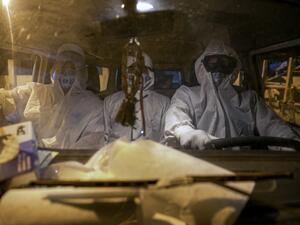 Gravediggers wearing protective clothing arrive in a funeral home's car at the Recanto da Paz Municipal Cemetery to bury a victim of the novel coronavirus COVID-19, in the city of Breves, southwest of Marajo Island, an island at the mouth of the Amazon River in the Brazilian state of Para, on May 30, 2020. The pandemic is spreading across Brazil under a cloud of confrontation, as governors and mayors implement restrictive measures while President Jair Bolsonaro, who has pinned his hopes of re-election on a 