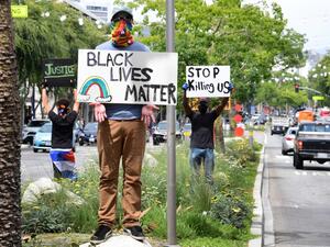 Activists hold placards in the middle of Santa Monica Boulevard in West Hollywood, California over the death of George Floyd, on June 1, 2020. The city and county of Los Angeles has extended curfew for a third night following a weekend of looting in southern California by people taking advantage of those protesting the death of George Floyd. Frederic J. BROWN / AFP