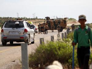 A shepherd boy leads his flock near Turkish soldiers standing outside an armoured vehicle part of a joint Turkish-Russian military patrol along the M4 highway in Ariha in the rebel-held northwestern Syrian province of Idlib on June 2, 2020. Abdulaziz KETAZ / AFP