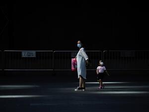 A woman and a child wearing face mask walk out of a mall in Beijing on June 2, 2020. WANG ZHAO / AFP