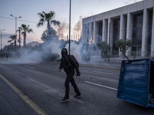 A protester walks among tear gas during clashes in a demonstration outside the U.S. embassy in Athens, on June 3, 2020, after George Floyd, an unarmed black man died after a police officer knelt on his neck during an arrest in Minneapolis, USA. Angelos Tzortzinis / AFP