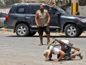 A fighter loyal to the UN-recognised Libyan Government of National Accord (GNA) prostrates in prayer as an expression of gratitude as his comrades celebrate in the Qasr bin Ghashir district south of the Libyan capital Tripoli on June 4, 2020, after the area was taken over by pro-GNA forces following clashes with rival forces loyal to strongman Khalifa Haftar. The GNA said on June 4 that it was back in full control of the capital and its suburbs after more than a year of fighting off an offensive by eastern 