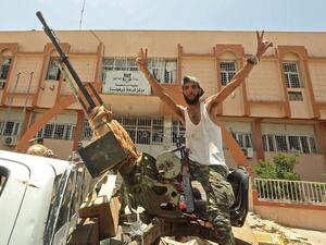 A fighter loyal to Libya's UN-recognised Government of National Accord (GNA) poses for a picture while seated in the turret a technical (pickup truck mounted with turret) in the town of Tarhuna, about 65 kilometres southeast of the capital Tripoli on June 5, 2020, after the area was taken over by pro-GNA forces from rival forces loyal to strongman Khalifa Haftar. The GNA said on June 5 that it was back in full control of Tarhouna, the last stronghold of the forces of eastern strongman Khalifa Haftar. The UN