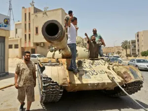 Fighters loyal to Libya's UN-recognised Government of National Accord (GNA) stand atop a tank in the town of Tarhuna, about 65 kilometres southeast of the capital Tripoli on June 5, 2020, after the area was taken over by pro-GNA forces from rival forces loyal to strongman Khalifa Haftar. The GNA said on June 5 that it was back in full control of Tarhouna, the last stronghold of the forces of eastern strongman Khalifa Haftar. The UN-recognised government had announced the day before that they were also in fu