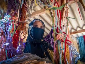 A Moroccan rug weaver sorts out yarn at a workshop in the city of Sale, north of the capital Rabat, on June 3, 2020, during the novel coronavirus pandemic. Artisans in Morocco have been starved of income for almost three months because of the COVID-19 pandemic. The crafts industry represents some seven percent of GDP, with an export turnover last year of nearly 1 billion dirhams ($100 million). FADEL SENNA / AFP