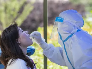 A medical worker takes a swab sample from a student to be tested for the COVID-19 coronavirus at Wuhan University, on the first day of classes in Wuhan on June 8, 2020. Final year students returned to campuses in Wuhan after universities were reopened following a months-long closure due to the coronavirus. STR / AFP