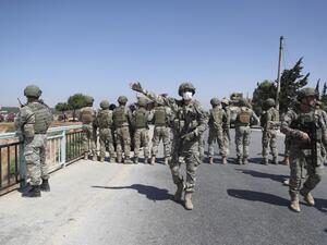 Turkish soldiers stand guard on a bridge overlooking a section of the M4 highway, which links the northern Syrian provinces of Aleppo and Latakia, during a joint Russian-Turkish military convoy near Ariha in Syria's rebel-held northwestern Idlib province, on June 10, 2020. OMAR HAJ KADOUR / AFP