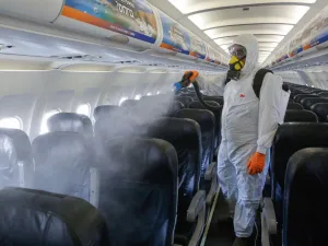 An Israeli worker in full hazmat suit sprays disinfectant in the cabin of an Israir Airlines Airbus A320 airplane, at the Ben Gurion International Airport near the central Israeli city of Tel Aviv, on June 14, 2020, amid the novel coronavirus pandemic. GIL COHEN-MAGEN / AFP