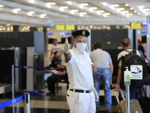 An Egyptian policeman, wearing a protective face shield, signals to passengers at the Sharm el-Sheikh international airport on June 20, 2020. Khaled DESOUKI / AFP
